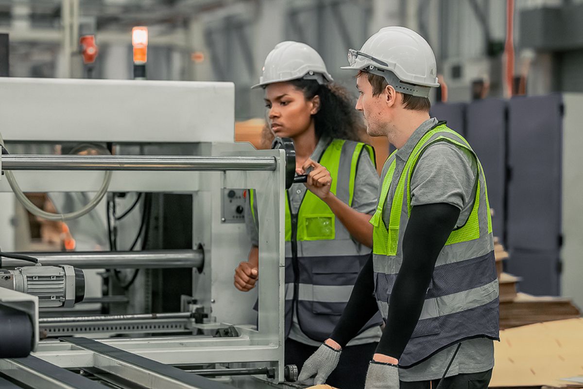 Two workers inspecting manufacturing equipment