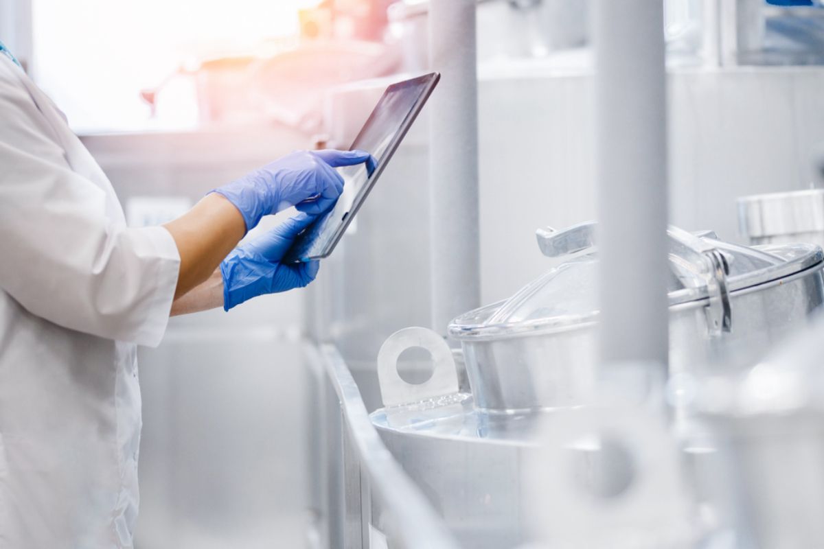Gloved hands of a technician adjusting automated equipment