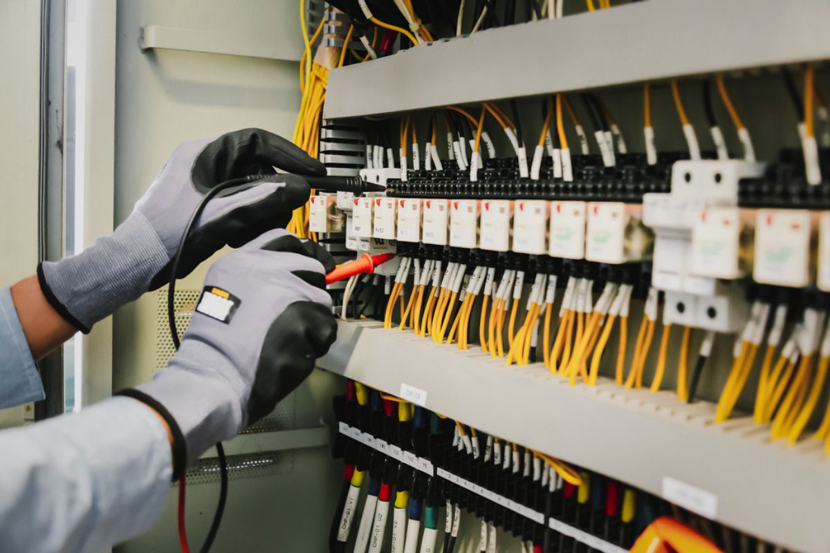 Close-up of worker inspecting a wire harness panel